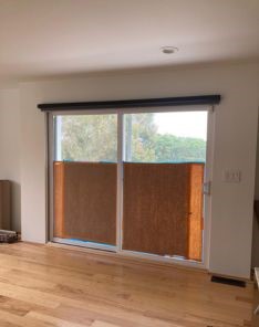 Sliding glass doors with automatic shades that filter sunlight and enhance privacy in a contemporary home interior.