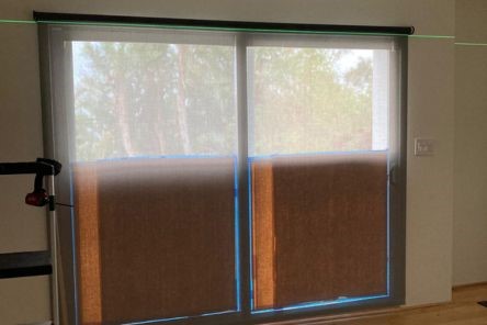 Sliding glass doors with stylish automatic shades, providing seamless indoor window coverings that offer privacy and light control in a contemporary interior.