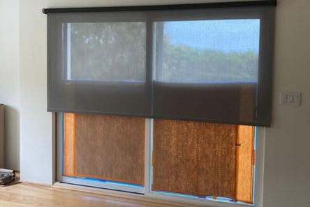Sliding glass doors fitted with sleek automatic shades, offering stylish window covering options that enhance privacy and light management in a contemporary home interior.