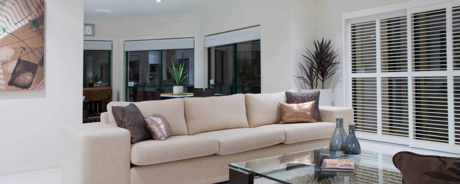 A view on a luxurious living room with sliding white window shutters